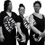 A black and white photo of three African American women in elegant black dresses. 
