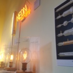 An image of various types of light, including neon light, as displayed in a museum space. 