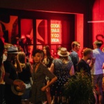 A group of people stand outside a club.