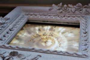 An old frame with a spiral pattern in it. 