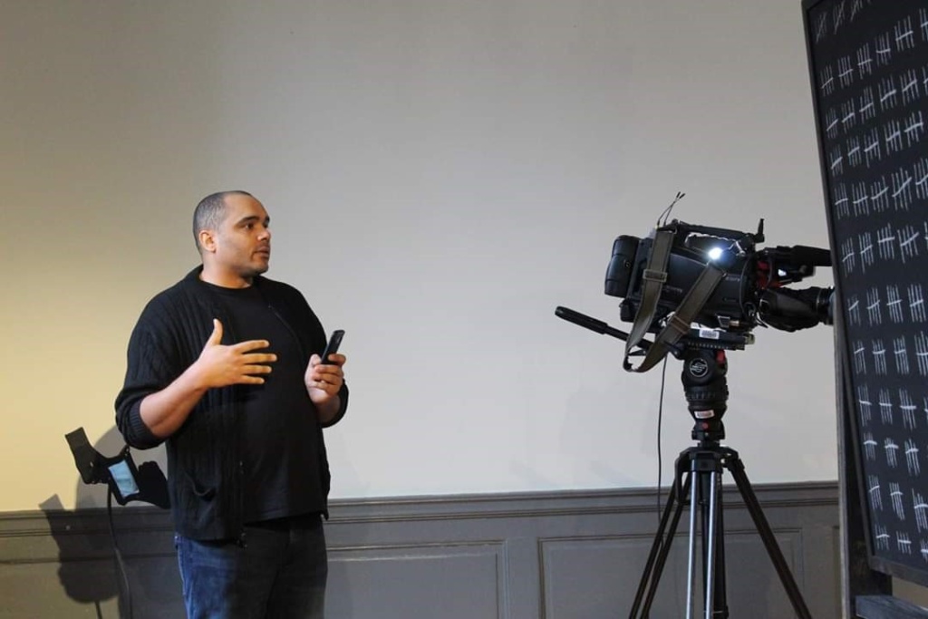 Renovations artist Christopher Kojzar, who is standing in front of a camera. 