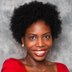 Maya Wilson wears a bright red shirt and golden hoop earrings.