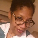 Krista Green wears glasses and a white collared shirt.